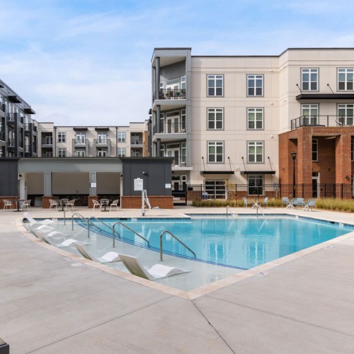 a courtyard with a pool and chairs