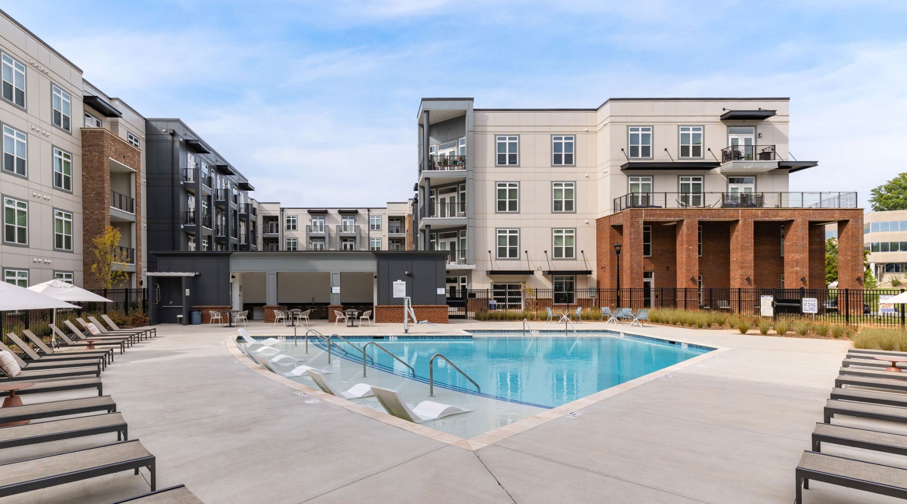 a courtyard with a pool and chairs