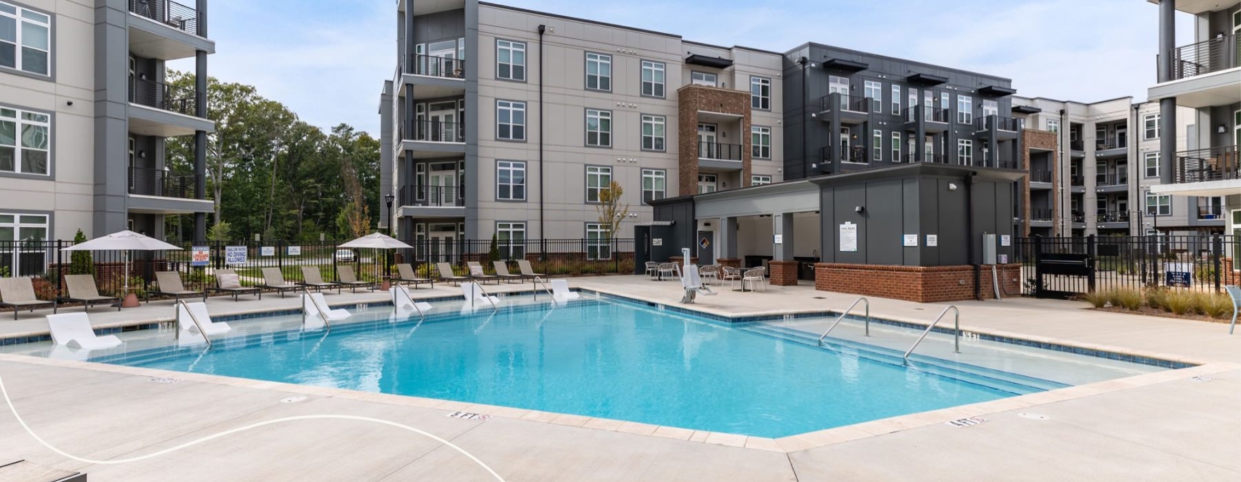 a swimming pool with chairs in a courtyard