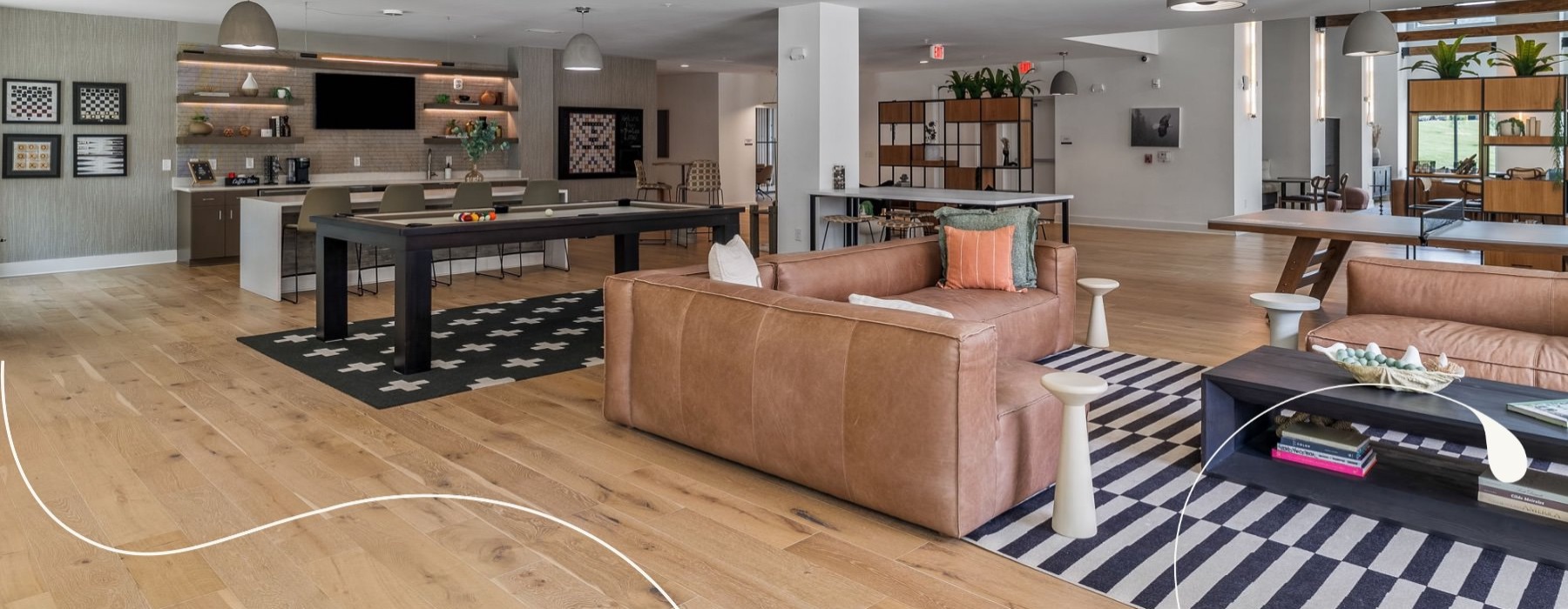 a clubroom with a pool table, couches and tables