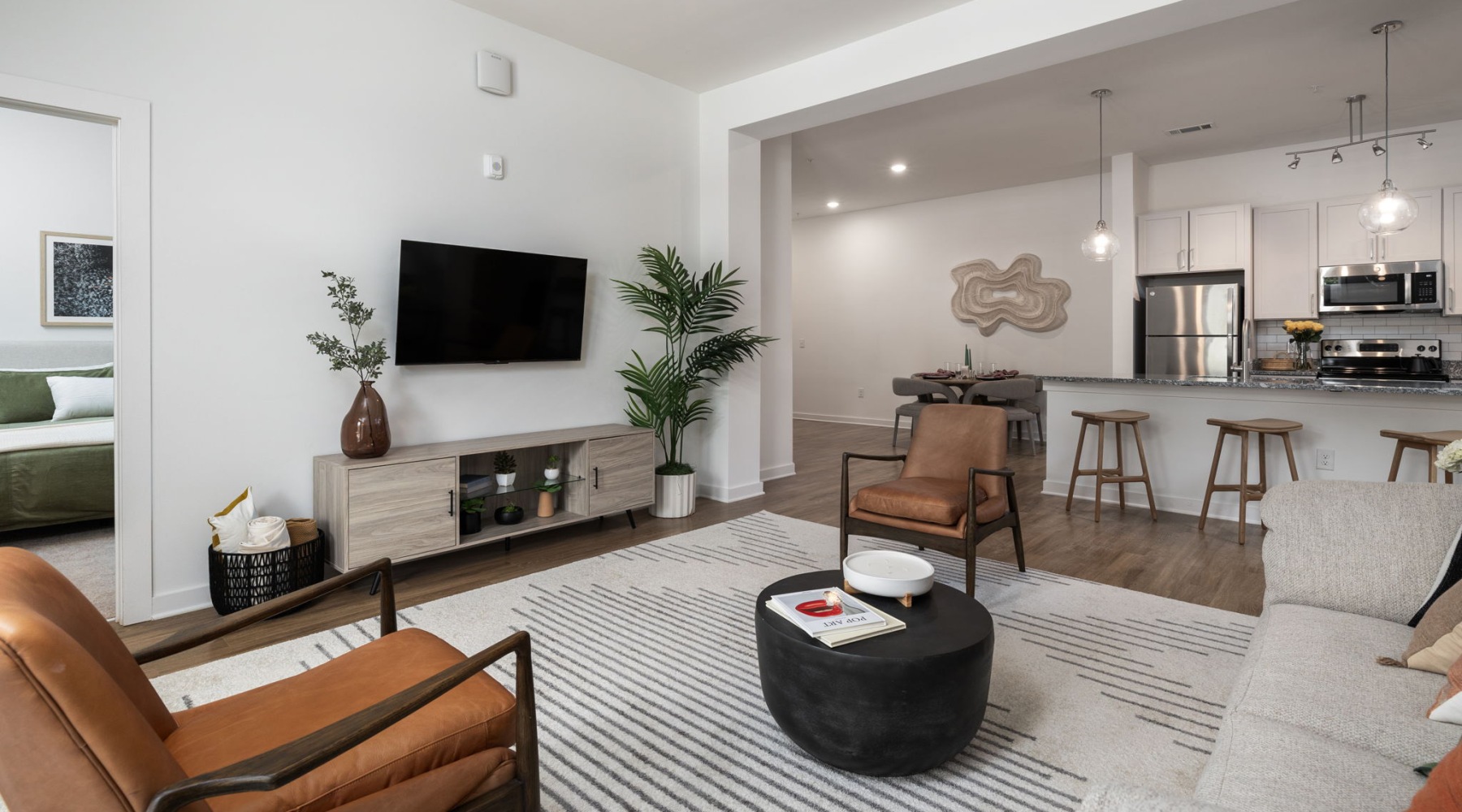 living room with seating table tv and kitchen in view